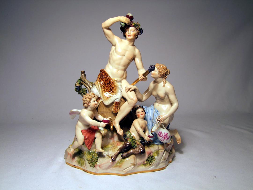 19th Century Meissen Figural Group With Bacchus : Four figure grouping with Bacchus seated upon a keg of wine holding his scepter in one hand and chalice of wine in the other while a bare breasted female is pouring wine into the chalice of a young Sa
