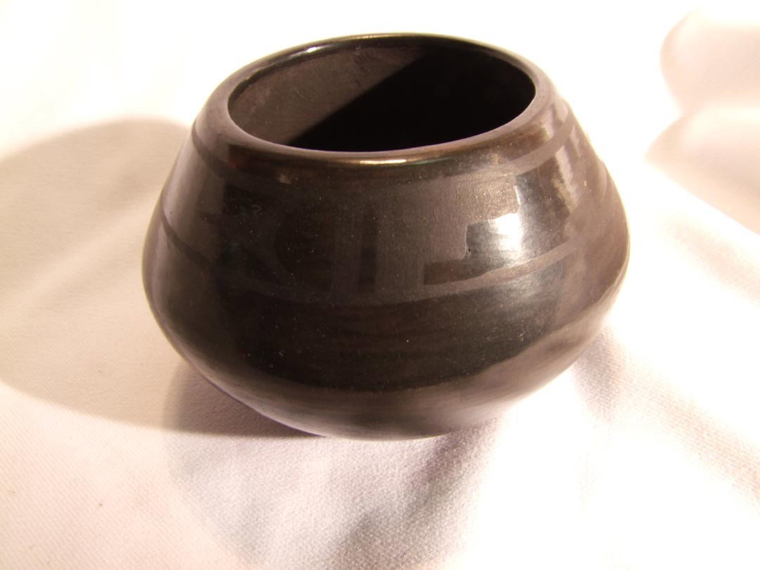 Santa Clara Pottery: Glossy back pot with geometric band around top, pencil signed Lucy and Rienerd. 3 1/4" high.