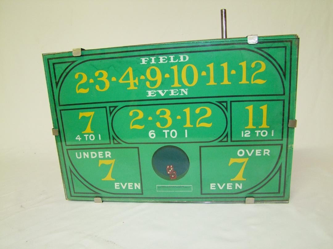 Counter Top Gambling Dice Game: Much like the game "Dice Popper", this game has a steel rod that you pull forward and push back in that causes the display area to vibrate and tumble the dice around. The hand written box on the front