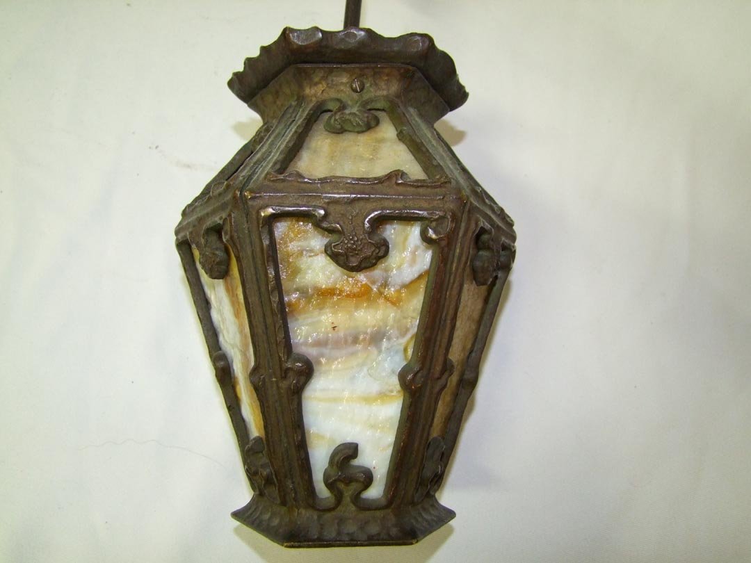 Arts & Crafts Bronze Hall Or Porch Light: Six sided fixture with each side having 2 sections of carmel slag glass. This fixture includes the hanger. No Makers Mark found. 7" diameter x 10 " with 8 1/2" hanger.
