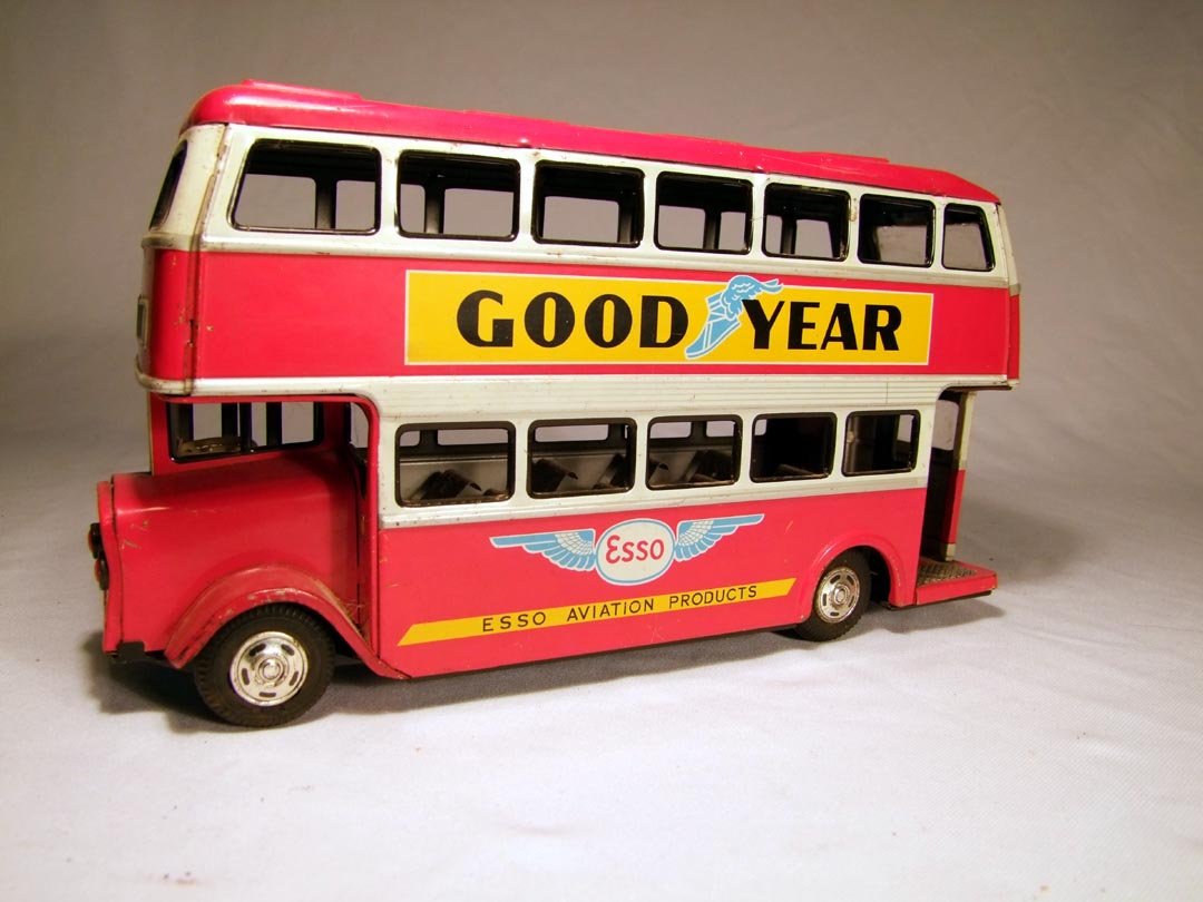 ATD Japanese Double Decker Bus With Advertising: Friction red bus with advertising on sides and back, front reads 18 London. 12" x 3 1/2" x 6 1/2" high. Hard rubber tires.