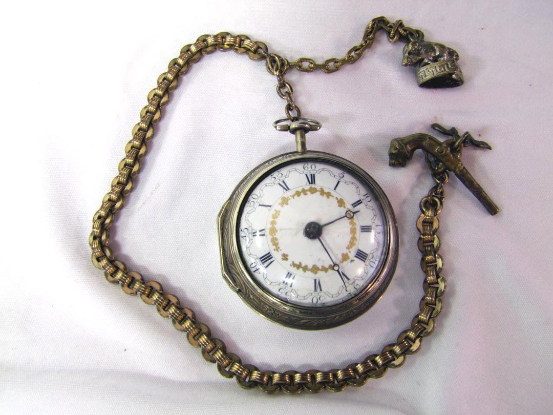1750 10K Gold Pocket Watch: Key wind watch and the key is on the watch chain in the shape of a gun. Painted porcelain dial with a crack at 9:00. Watch lifts out of the decorative protective out case. Works.