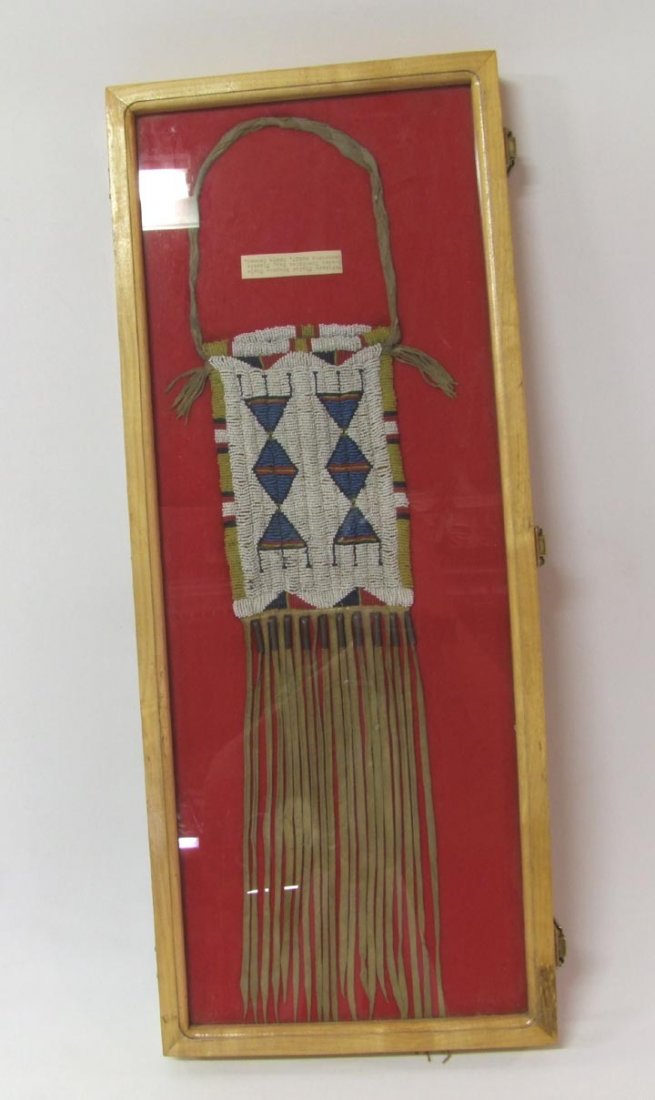 Northern Plains Indian Possibles Bag: Beaded on one side with greasy yellow, cobalt, blue and red upon a white beaded background. Braided leather handle. Bag measures 5 1/2" x 8 1/4" high with long 13" fringe. Top of the fringe has 10 tin