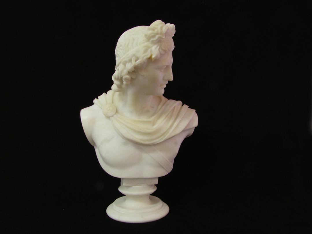 Alabaster Bust Of Apollo: Early 1900s Italian carved alabaster bust of Apollo, the Greek God of the Sun. Unsigned sculpture positioned on a round swivel base 7 1/2" in diameter, sculpture is 14" wide at shoulders and overall h