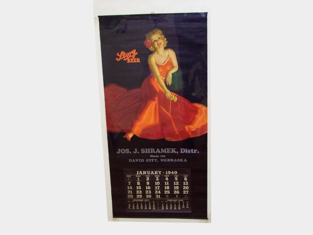 1940 Storz Beer Calendar By Moran: Advertising calendar for Jos. J. Shramek, Dist., David City, Nebraska. Artwork by Earl Moran showing a very attractive woman reclining on a bolster with the Storz Beer logo at her side. The Storz brew
