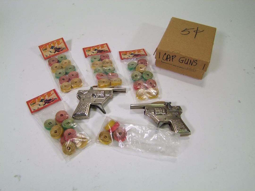 Cap Guns: Two Hawk cap guns and four unopened bags of caps along with one opened and half used.