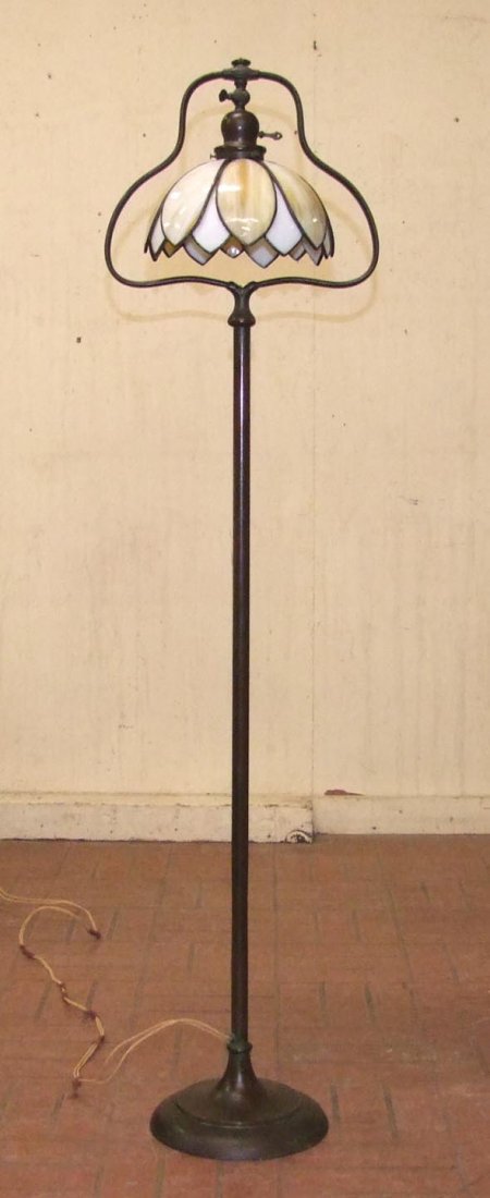 Handel Floor Lamp: 56" bronze floor lamp with adjustable socket to angle the shade. Fabric label on the round base. 9 3/4" diameter unsigned lily pond shade made of milk glass and caramel glass forming the flower. Cord 