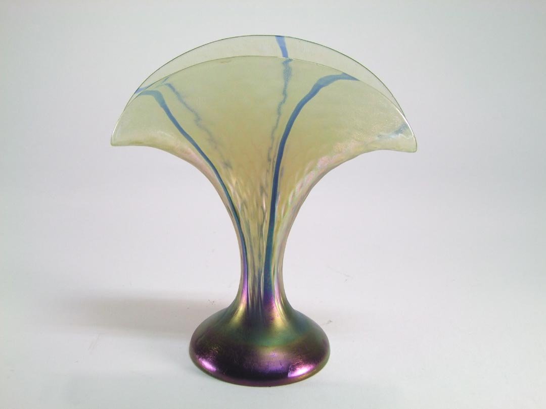 Loetz Fan Vase: Unsigned Loetz fan vase with nice even form having blue lines pulled up from the purple iridescent base. No chips, cracks nor repairs. 4 1/4" diameter base 8 1/4" wide x 9 1/4" high.