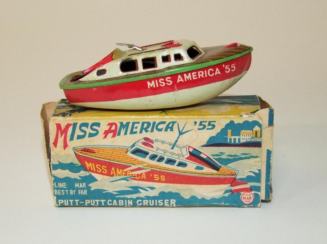"Miss America" Boat: Tin Miss America putt-putt cabin cruiser by Line Mar Toys missing the candle tray and filler tube. Has original box that measures 4 1/2" x 2" x 1 1/2". Light scuffs.
