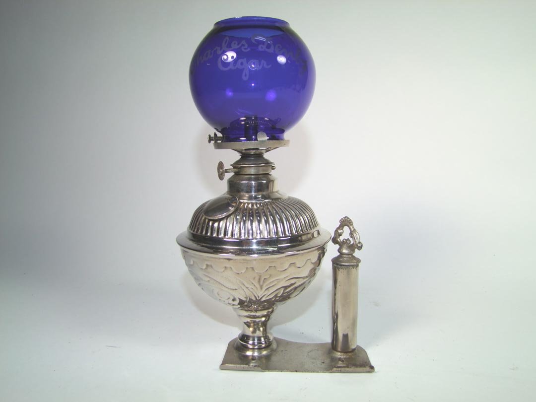 Denby Advertising Cigar Lighter: Cobalt blue globe etched "Charles Denby Cigar". The base is designed to attach either to the counter or onto a cigar cutter. 9" high includes the globe. No damage other than a few dimples in the metal