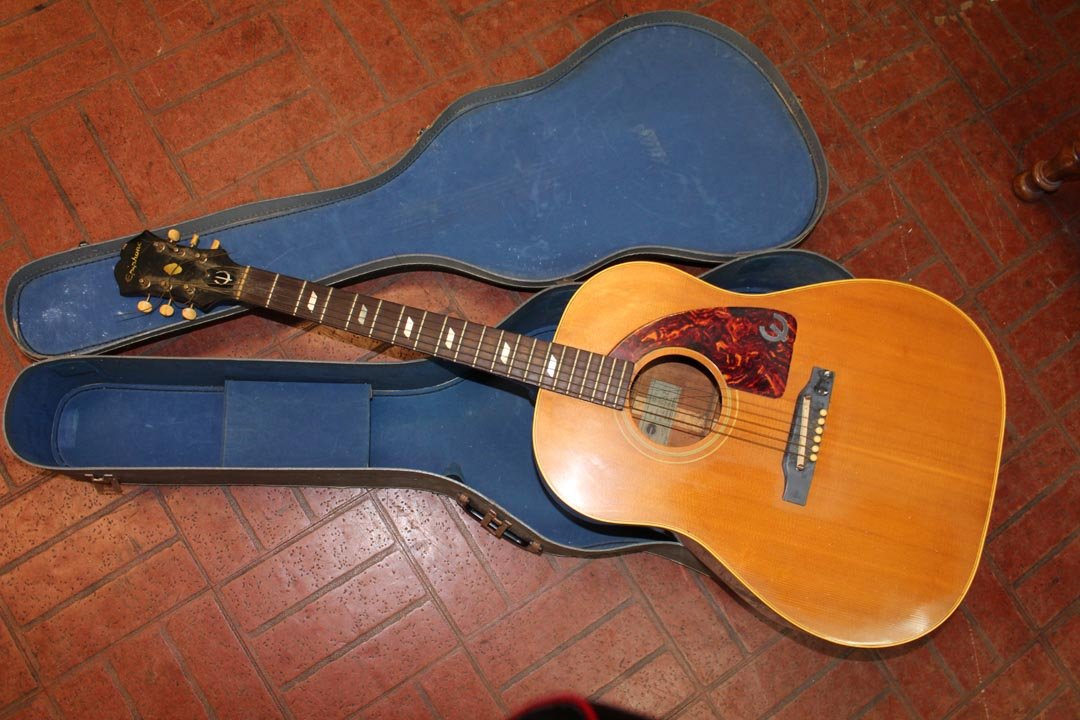 Epiphone Guitar: Texan acoustic guitar style ET79N in good condition. Broken string and needs light cleaning. Chip in ebony veneer above Epiphone.