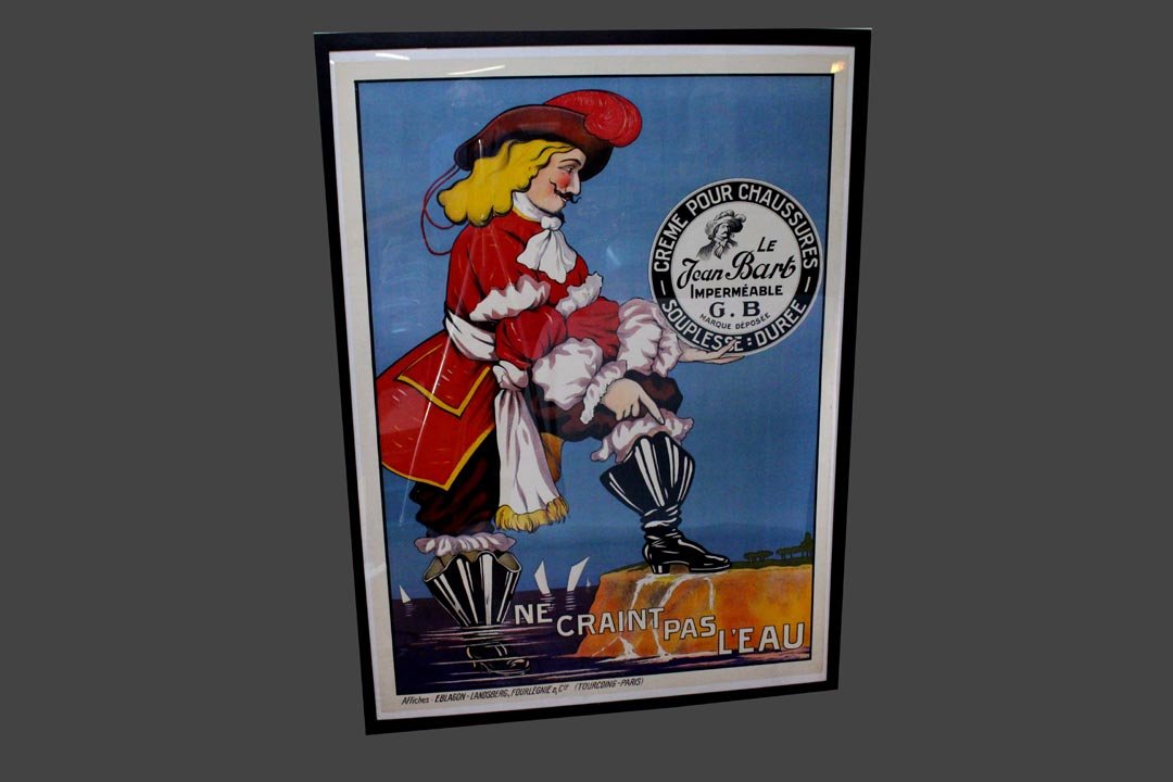 French Advertising Poster: Poster advertising water proof shoe polish with the pirate standing next to the shore with one foot in the water. Not removed from frame for inspection has plexiglass protective front. 46 1/4" 62 1/2"