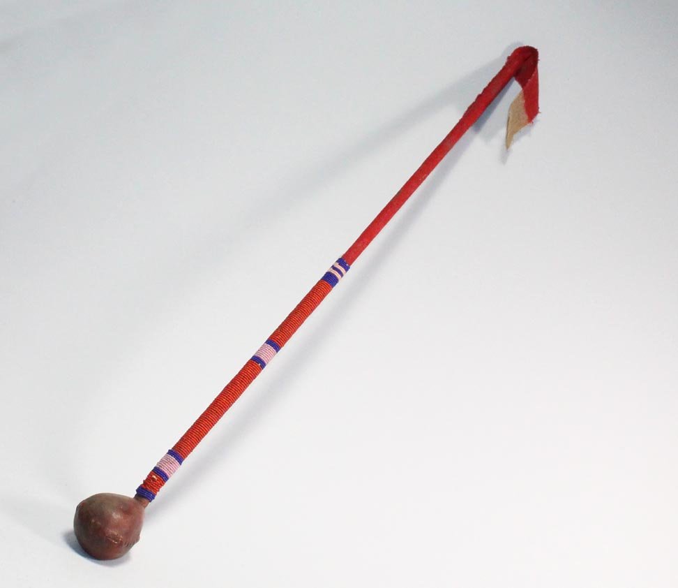 Cherokee Skull Cracker: 1880s Cherokee Indian Skull Cracker with buckskin covered stone. 27" plus 4 1/2" dyed red trade cloth tail. Beaded with red, mauve and cobalt glass beads. Very good condition.