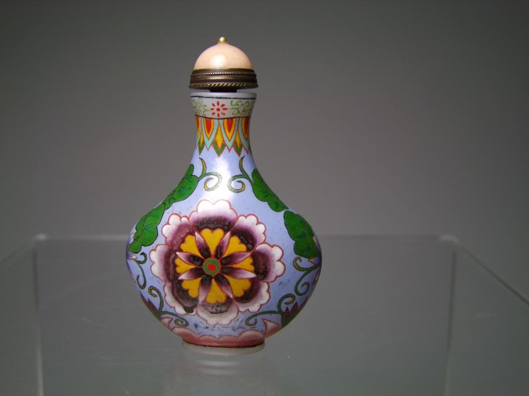 Chinese Snuff Bottle: White Peking glass bottle with enamel painted flowers and design with the Qianlong production mark on the bottom. Pink hardstone cap with brass scoop. 3" high. Very good detail and condition.