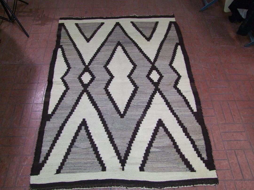Navajo Rug: 4' 6" x 6' 3" with dark brown, grey and cream. Binding edge loose in areas. 1940 - 1950s.