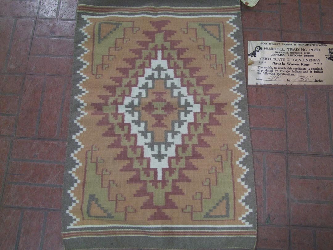 Navajo Rug: 2' x 3' multi colored rug with certificate indicating that it was made by Angelia Segay in Pine Springs, Az. Mid 20th century. Very good condition.