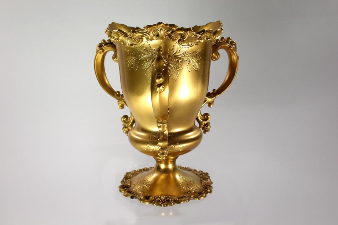 Black Starr & Frost Gilt Sterling Loving Cup: Trophy size three handled loving cup gilded on sterling with raised scrolling leaf design around the top and repeated around the base. Chased leaf design on the body where the handles are attached at 