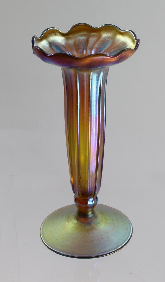 Footed Gold Tiffany Vase: Ribbed body up to a 4" diameter scalloped top 4" diameter base x 8 1/2" high signed L.C.Tiffany - Favrile 5 - 7218 N 1548. Even iridescence with colorful highlights in very good condition.