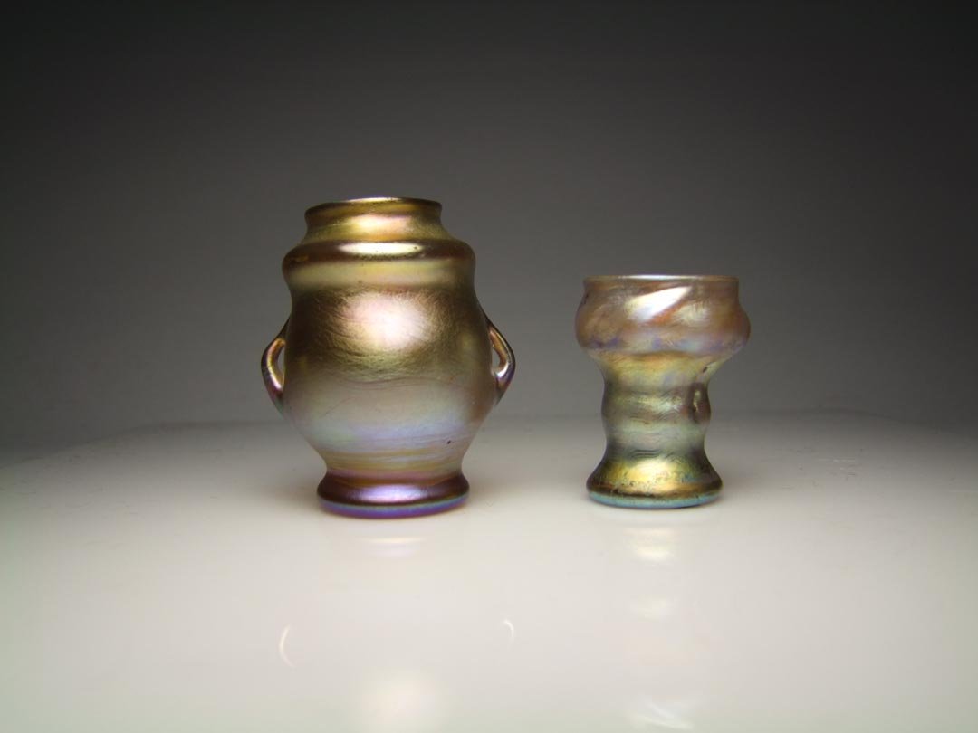 Two Gold Miniature Tiffany Vases: Gold double handle vase 2 3/8" high signed L.C.T. Y3971. Gold goblet shape 1 3/4" vase with spiraling ribs signed L.C.T. M6384. Both pieces in very good condition with good iridescence.