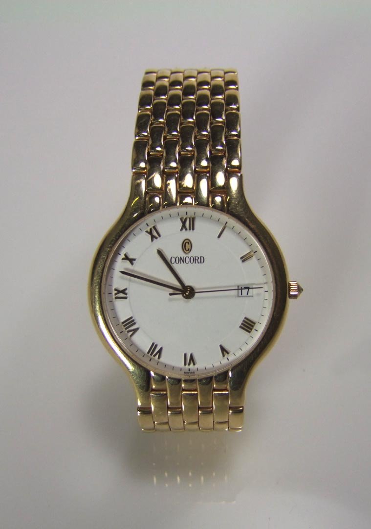 14K Concord Watch: 14K yellow gold Concord Panther watch with round case and white dial. Seven link 14K gold band with fold-over clasp. Serial number 127830 and reference number 28-14-268. 48.0 dwt. Working quartz movem