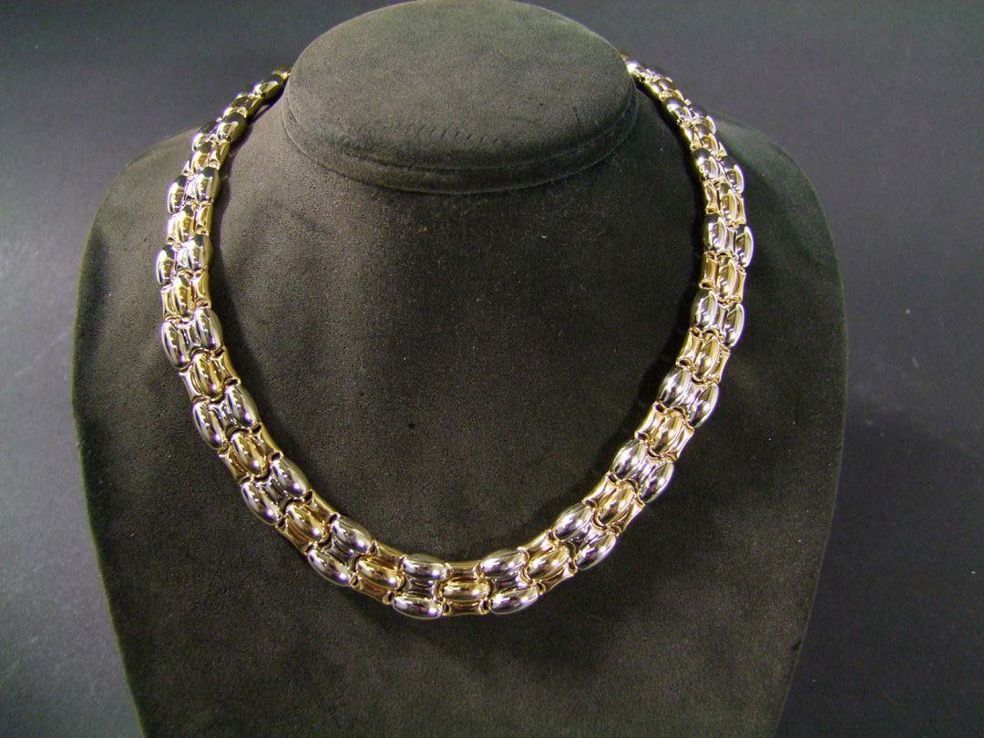 18K Gold Chimento Necklace: Stamped 750 for 18K yellow and white gold 15mm wide 17" necklace with high polish finish. Modified three-band panther design with two-button release prong closure. 37.84 dwt. Shows very little use.