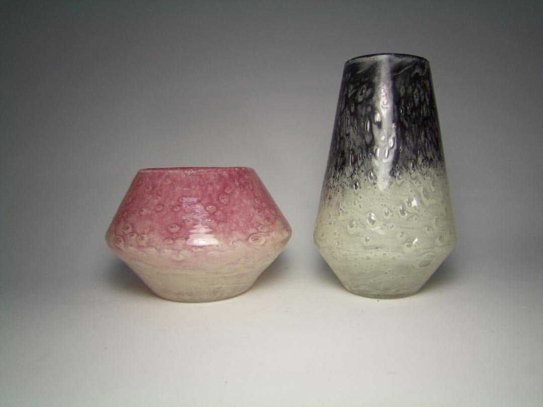 Two Pieces Steuben Cluthra Glass: Rose down into milky white with 4" diameter top, 6 3/4" diameter body x 4 1/2" high. Black down into milky white vase 7 3/4" high. Both pieces unsigned and in very good condition.
