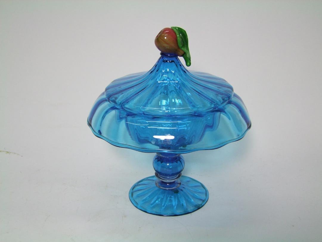 Blue Steuben Covered Compote: 4 1/2" diameter base with clear glass discs above and below a centered blue ball forming the stem up to the rolled edge bowl. The lid fits securely and has a glass apple as the finial. 8" diameter x 9