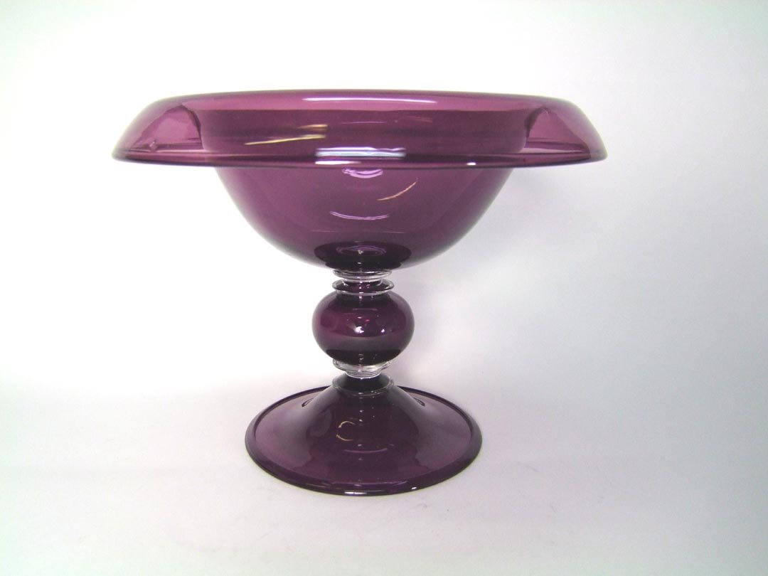 Purple Steuben Console Bowl: Roll over edge bowl on a pedestal having a round ball and clear glass discs raised on a 5 1/4" diameter foot. 7" high with a few small internal bubbles otherwise very good condition.