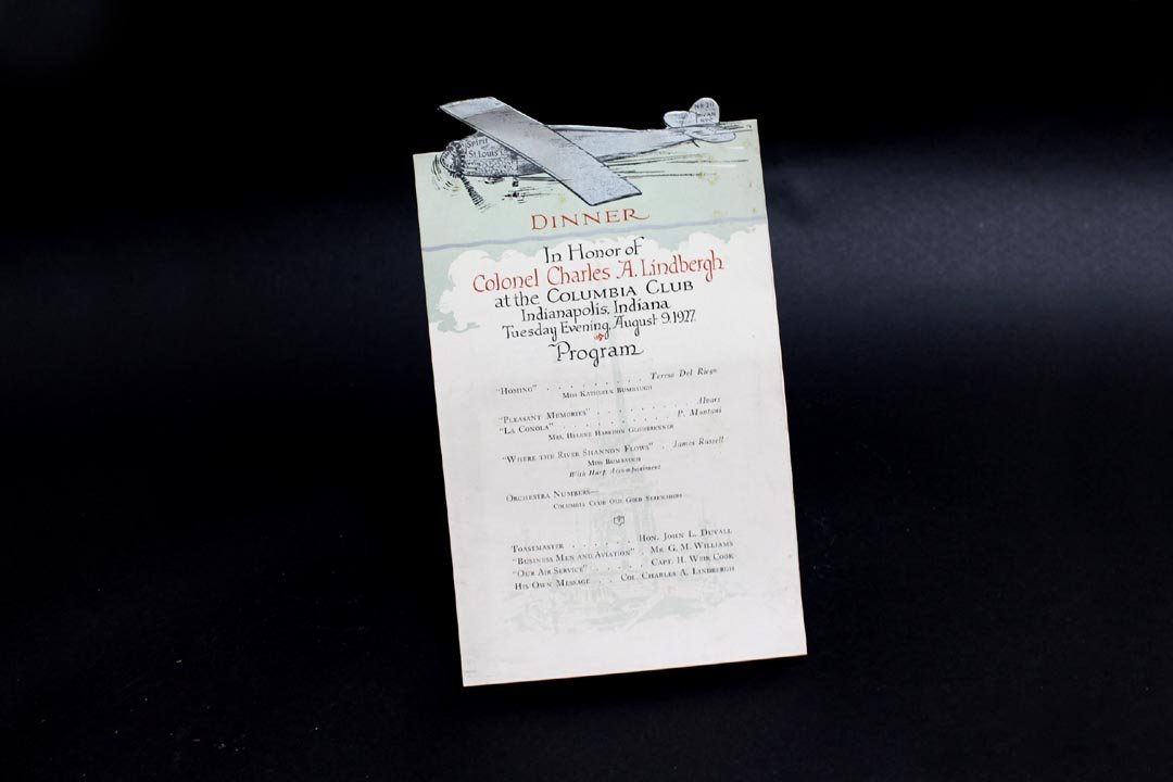 Charles Lindbergh Dinner Menu: Dinner menu and program in honor of Colonel Charles A. Lindbergh at the Columbia Club Indianapolis, Indiana Tuesday evening August 9, 1927. Autographed photo included. Die-cut paper extends the wing a