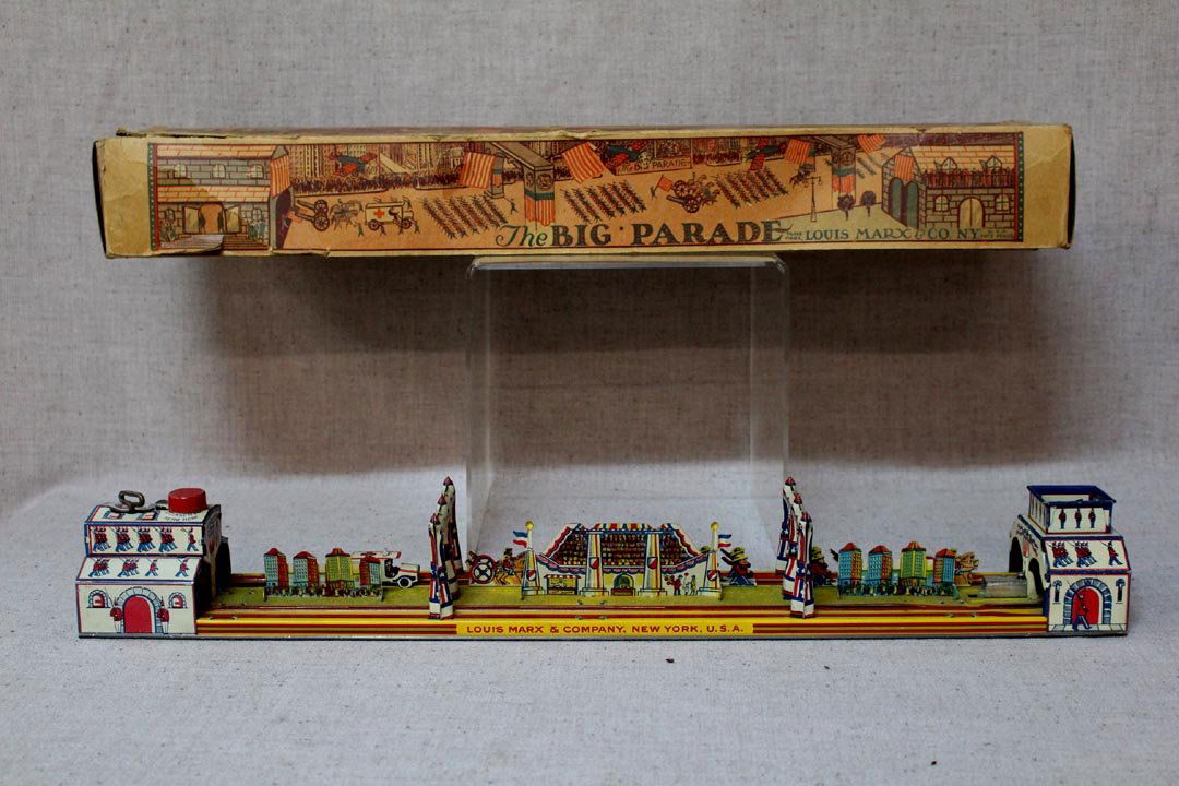 Marx, The Big Parade: 1928 tin wind-up toy parade by Louis Marx & Co. N.Y. minus the aeroplane. The original box is missing one end and has tears. Dent on base can be seen in the photos. Works.