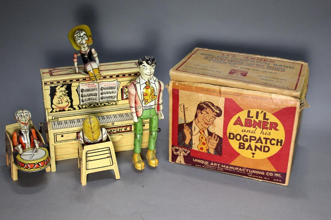 Li'l Abner And His Dogpatch Band: Lithographed tin wind-up toy bank by Unique Art Manufacturing Co. Inc. with original box that measures 7 1/2" x 5 1/2" x 6". Box has worn corners. Toy works but a little slow to get started.