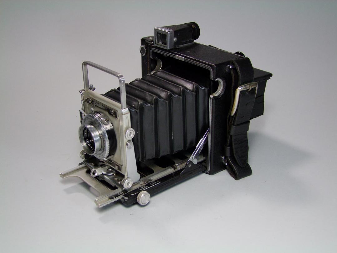 Graflex Crown Graphic Camera: Camera includes a very worn case and film pack cases. From a local collector. Chip in the glass shown in the photo.