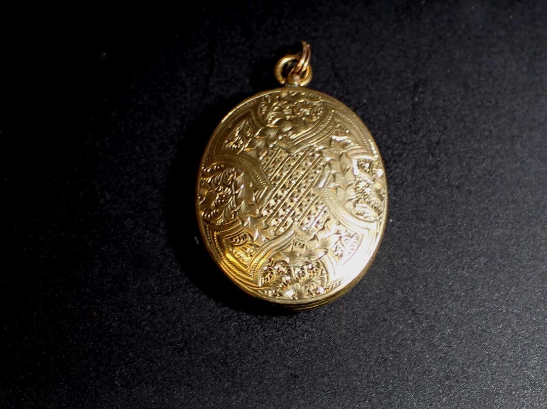 10K Yellow Gold Hair Locket: 19th century gold double locket with a blond lock of hair on one side and the other compartment is empty. 1 1/8" x 1 5/8" high. Strong hinge and engraved on both sides.