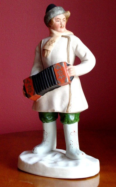 A Soviet Porcelain Figure of an Accordion Player: State Porcelain Manufactory, Dulevo, Moscow, 1924 Height 21,5cm Comments: