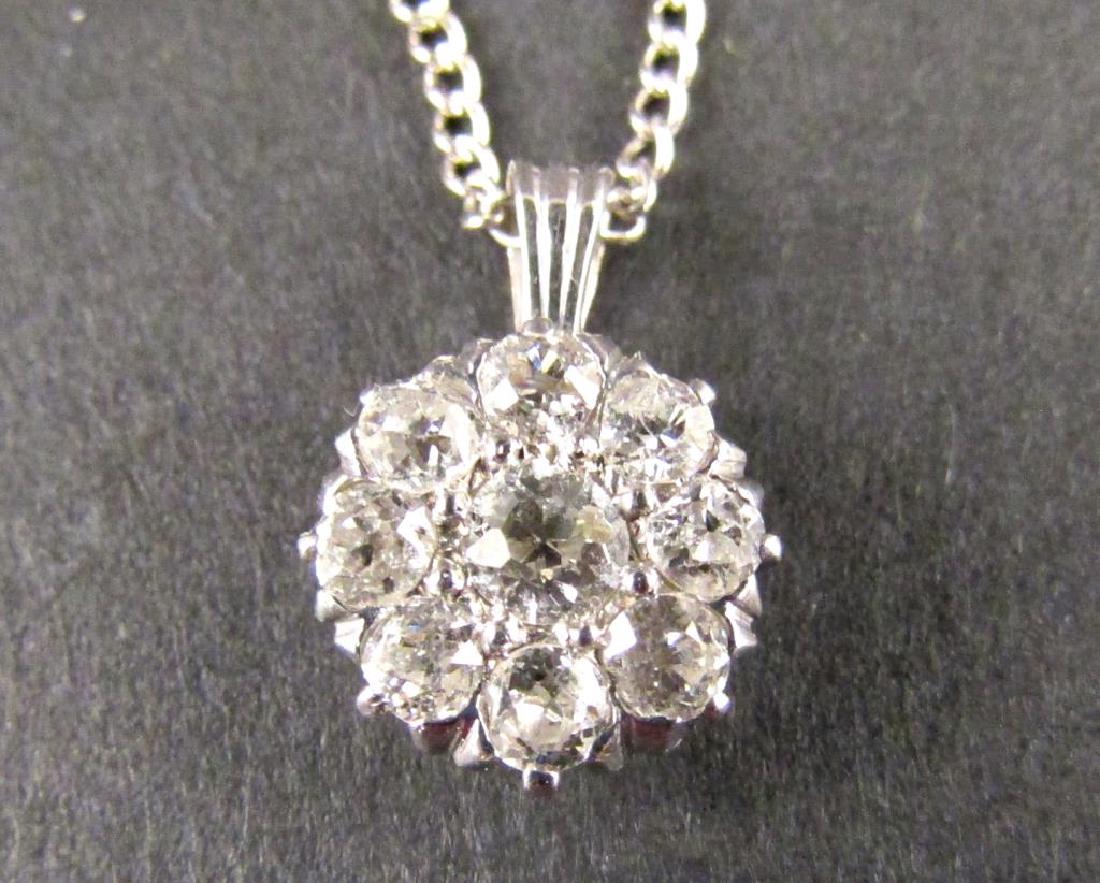 14K Gold and Diamond Pendant: On 14K white gold choker. 14.5 Center diamond with 8 surrounding in floral form."