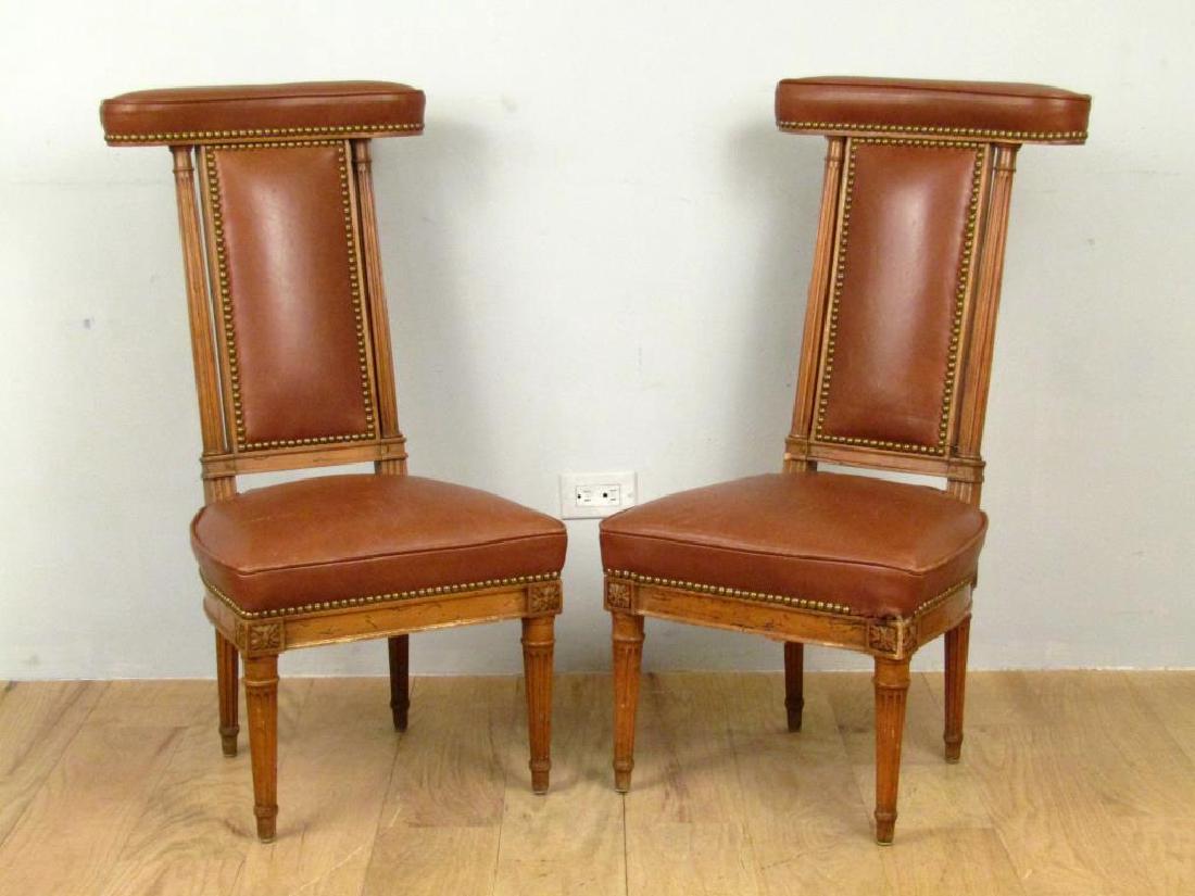 Pair English Cockfighting Chairs: Upholstered leather with brass trim, fluted back rails and legs, carved rosettes on apron. Losses as shown. 18W X 15"D X 35"H"