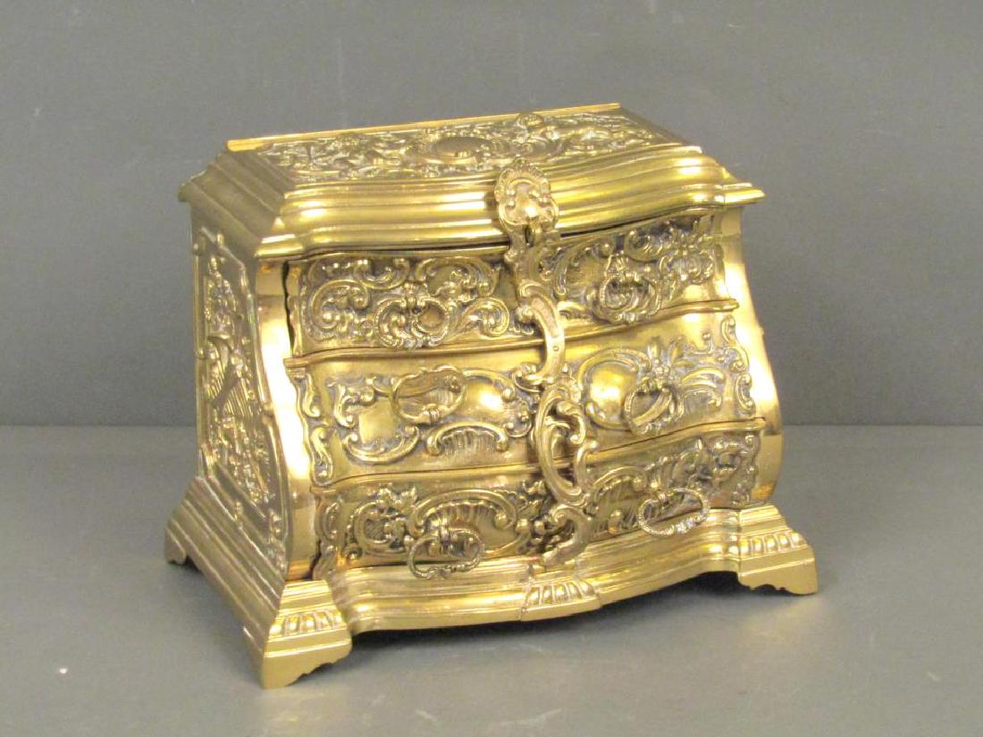 French Brass Jewelry Chest: Rococo manner with long scroll drawer cover over 3 drawers. Number stamp on back. Small lock with no key. 9.5" X 5.5" X 7.5"h.