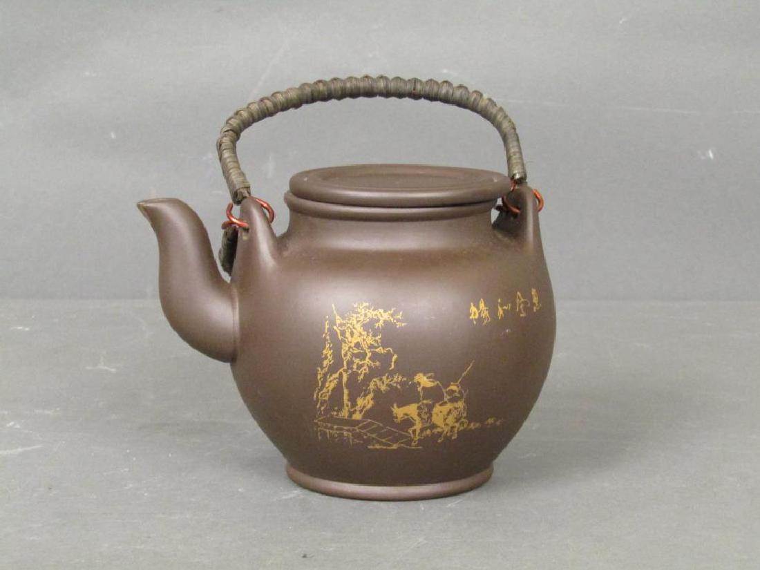 Japanese Clay Teapot: Two figures and donkey, writing on verso. Stamped on base. Rattan handles. 6.5"H