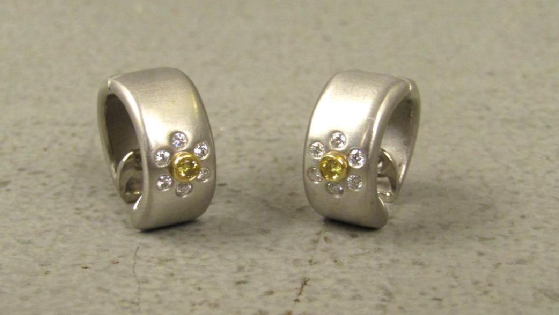 Pair Platinum, Diamond and 18K Gold Earrings: Hug earrings of brushed platinum, Each with 6 clear diamonds inset surrounding a yellow diamond mounted in 18K gold. 5/8" dia X 1/4" wide.