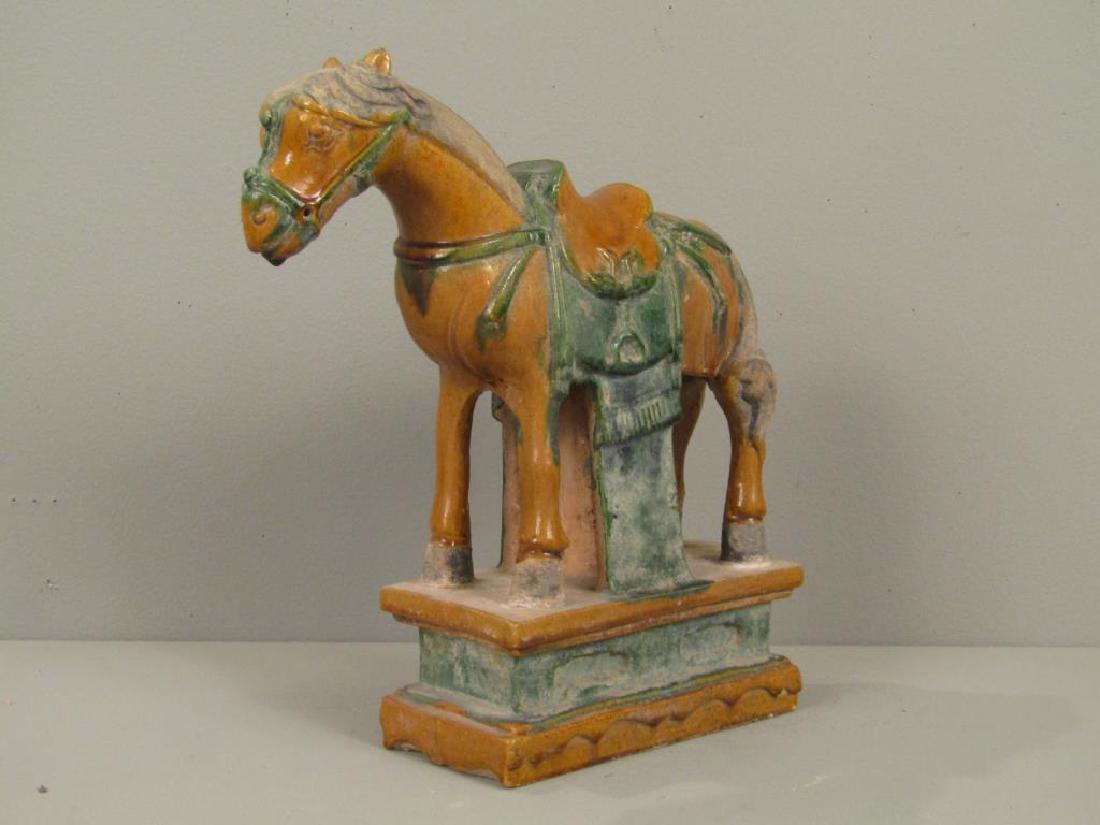 Ming Dynasty Chinese Caparisoned Horse: Ochre and green glazed pottery. Standing horse with saddle on a plinth base. 13"W X 4"D X 14"H. (24 Central Park South, NYC Estate) Professional Appraisal performed in 2001 available on request.)