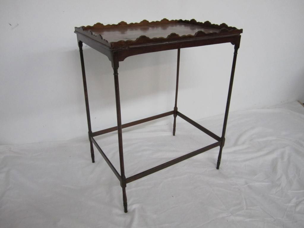 Antique English Tea Table: Scalloped gallery top on mahogany base. Thin legged outer stretcher base.
