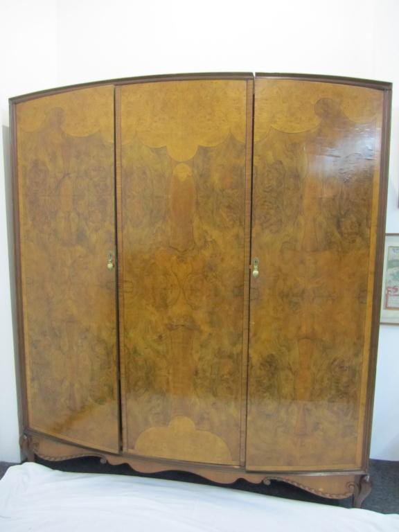 English Art Deco 3 Door Armoire Cabinet: Right side interior mirrored door with shelves and drawers. Double open center. Burled and scalloped inlaid front design with carved legs and Gadroon carved apron base. 71W X 83T X 21D. Disassembles f