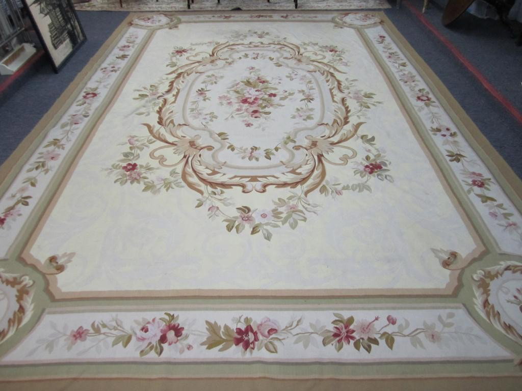 Aubusson Carpet - 10.6 X 16: Chocolate, tan and burgundy flowers and spandrels in center oversize medallion as well as well defined borders. Open ivory field. Mid to late 20th century, some stains.