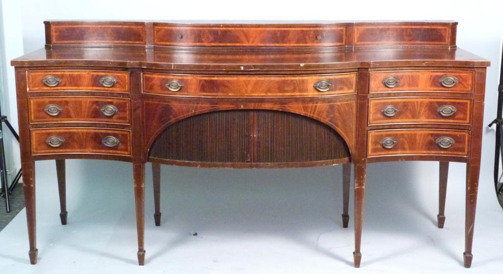 Hepplewhite Style Sideboard by Irwin: Tambour base door with cross banded drawers. Scratches in mahogany. 82W x 28"D x 43"H (535 East 86 Street Estate)"