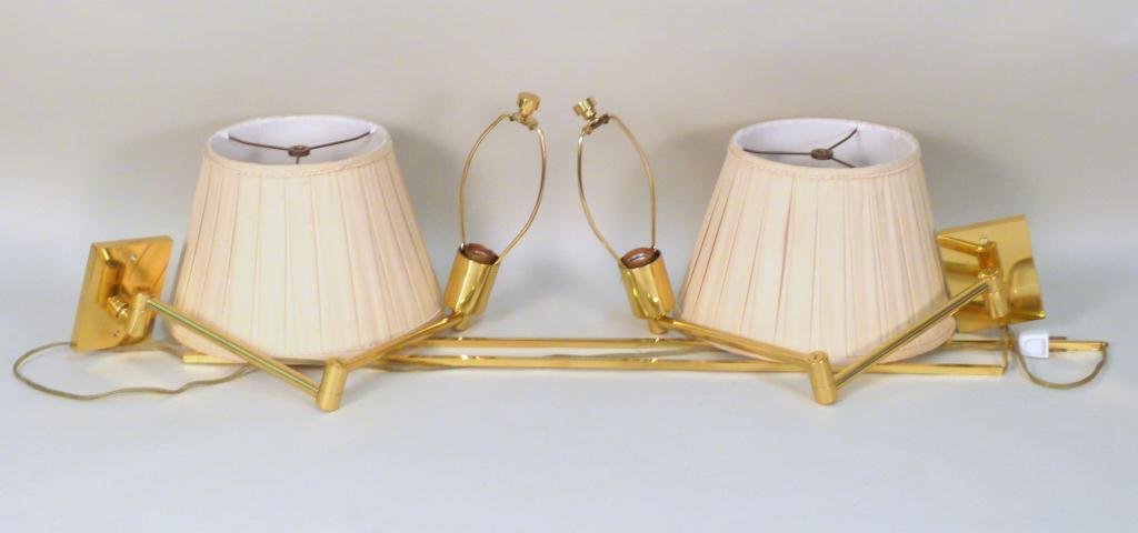 Pair of Hansen New York Sconces: Brass with swing arms. One with mounting plate. Two wire guards. And shades.