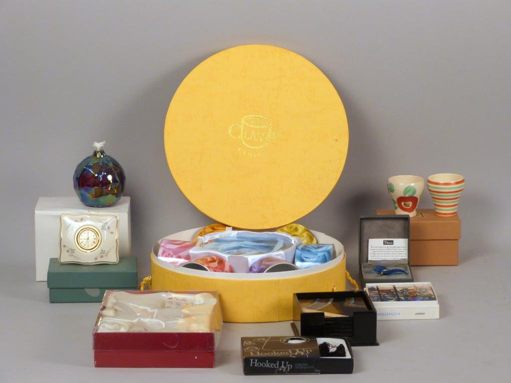 Nine Boxed Gift Items: One clock, one oil lamp, one set of coffee cups and saucers, Daum butterfly, two sets of coasters, one handbag hook, one set of doll items, and one pair of Japanese tea cups.