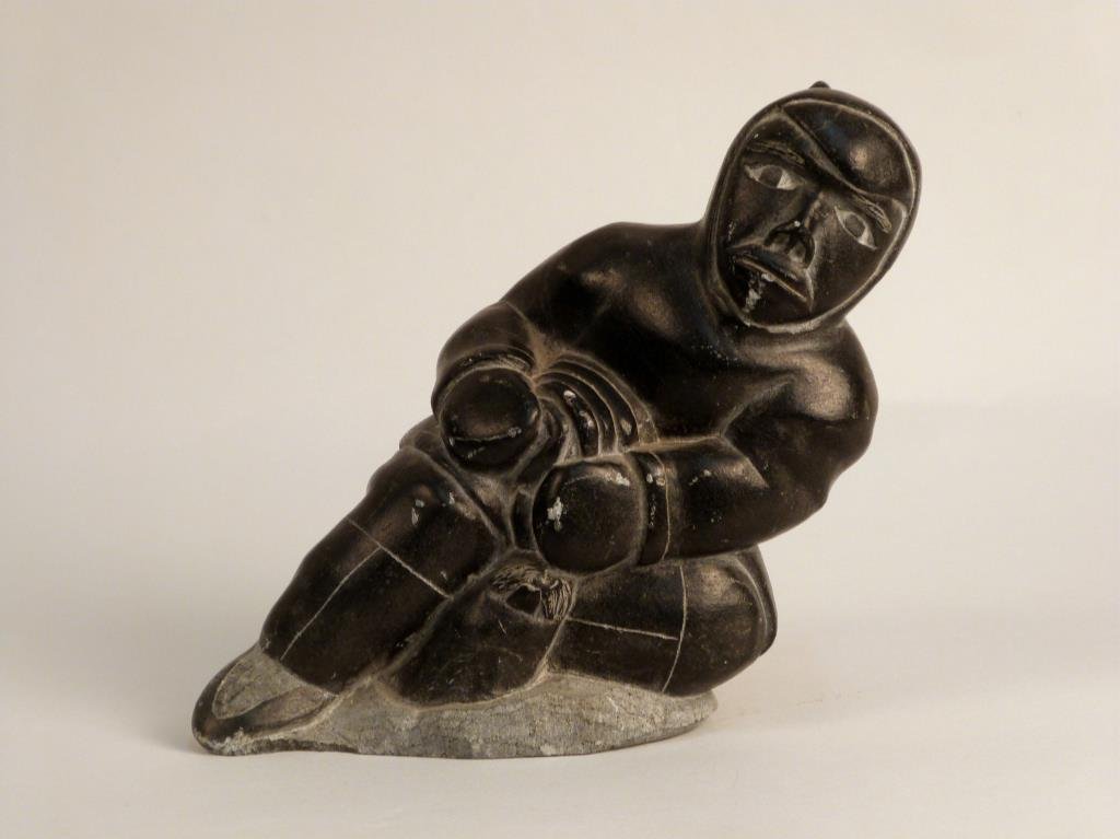 Inuit Stone Carving: Depicting a man and seal, inscribed Thomassie Iluta 80419, 6 W x 5" H."