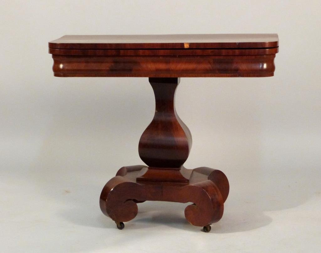American Empire Games Table: On baluster shaped pedestal, with four scroll feet on casters, 36" W x 17 1/2" D (open 35") x 30" H, restoration and losses to mahogany.