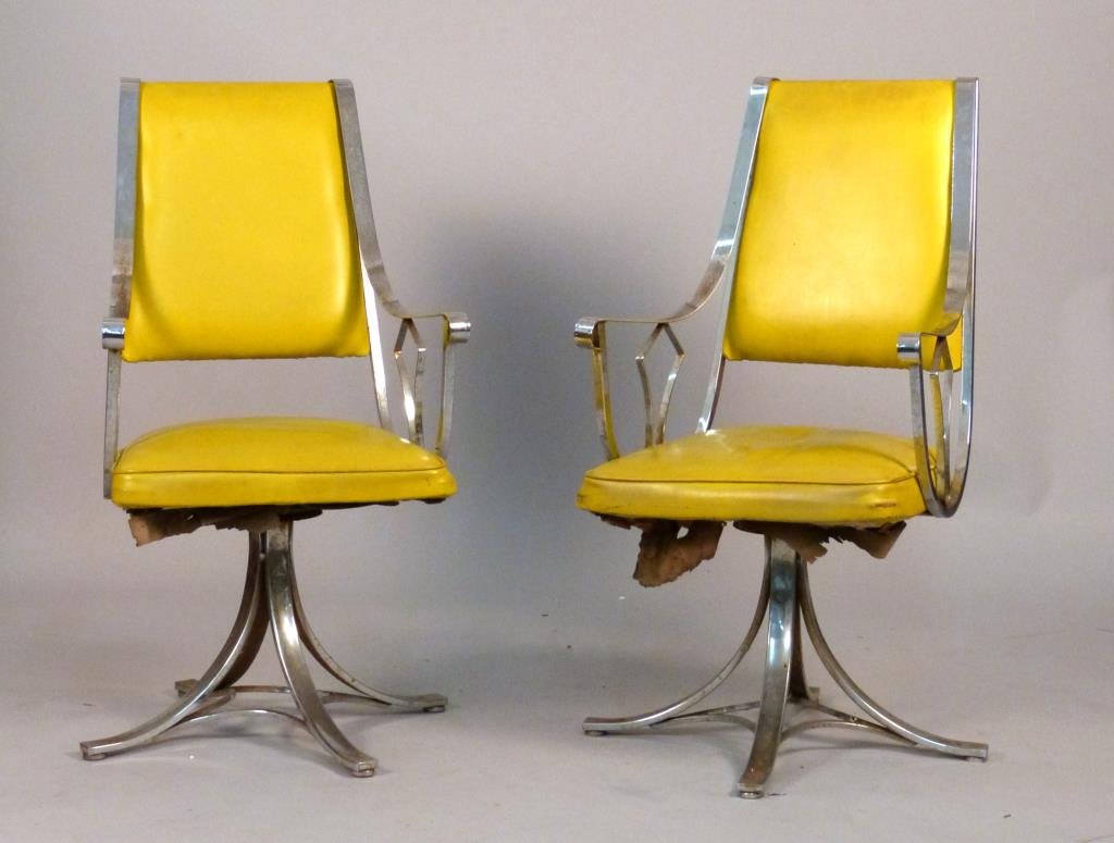 Pair Mid-Century Baughman Style Chrome Arm Chairs: Sloping chrome arms and bases, yellow vinyl upholstery, 21 1/2" W x 18" D x 40" H, frozen swivel, severe pitting. (Forest Hills Gardens Estate)