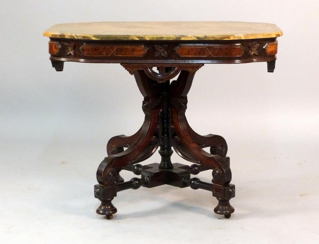 Victorian Eastlake Aesthetic Center Table: Carved apron and pedestal base, on casters, faux marble top. Gilt incised design after Pottier & Stymus. 37 1/2" W x26" D x 29 1/2"